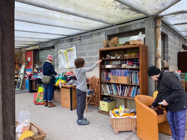 Des participants parcourent les vêtements, livres et objets de la donnerie.