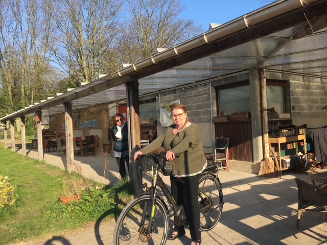 Des membres de l’équipe devant les locaux du jardin, avec un vélo.