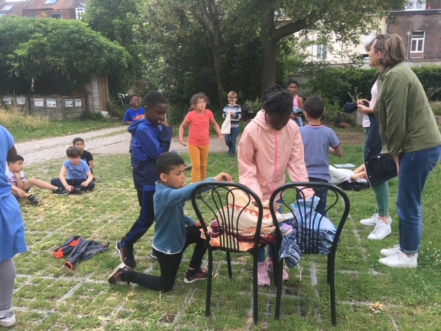 Des enfants participent à une animation autour des déchets en plein air.