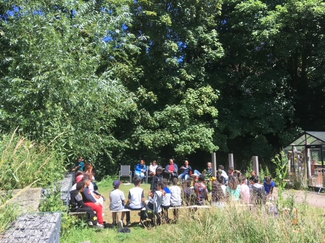 Un groupe scolaire est accueilli sous les arbres aux Jardins du Hêtre.